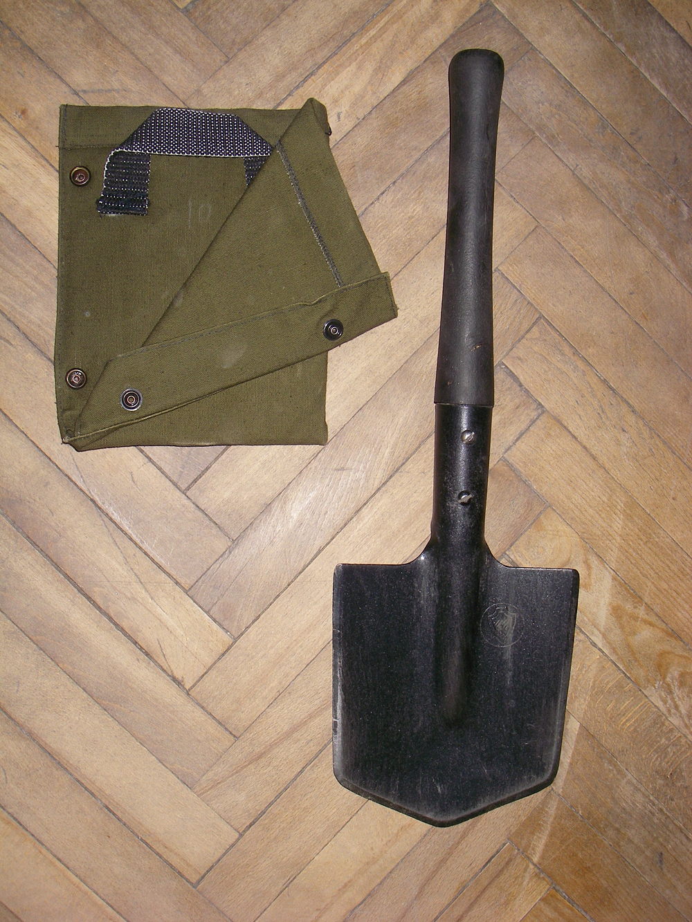 Post-WWII design. The blade cover to the left allows wearing the MPL-50 on the belt, in the blade up orientation.